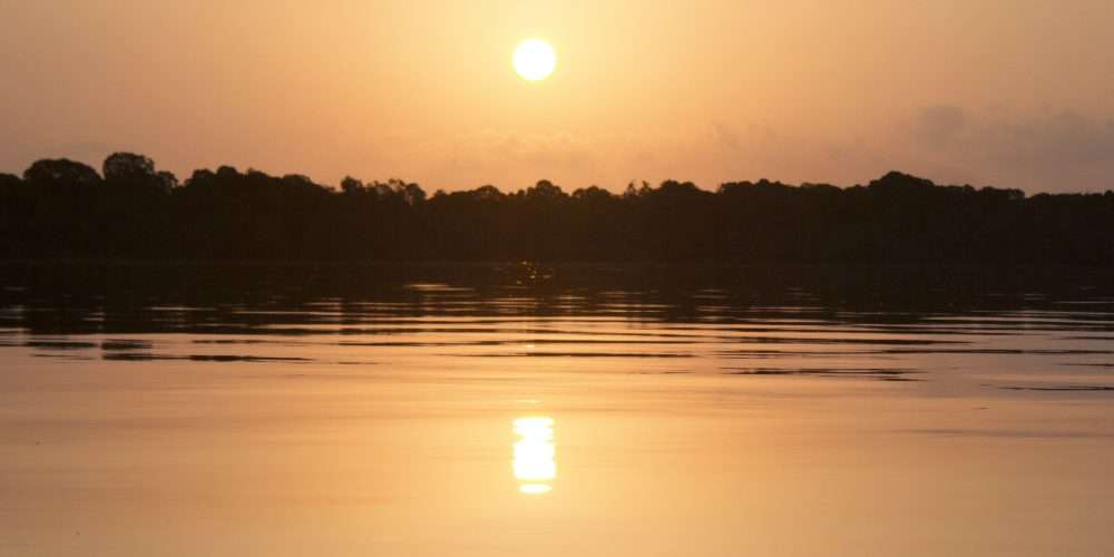 Tramonto su uno specchio d’acqua: dell’energia solare solo una parte arriva sulla Terra e una parte più piccola può essere utilizzata