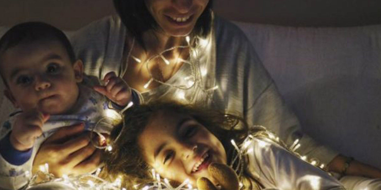 Bambini giocano con file di lucine: fin da piccoli possono essere educati al risparmio energetico