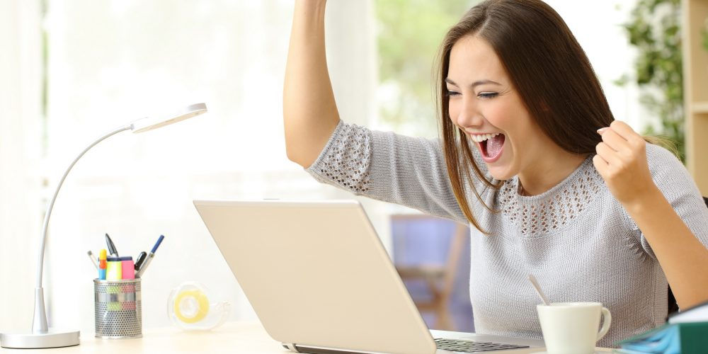 Una ragazza esulta davanti al computer: con un test si può conoscere il livello di risparmio energetico