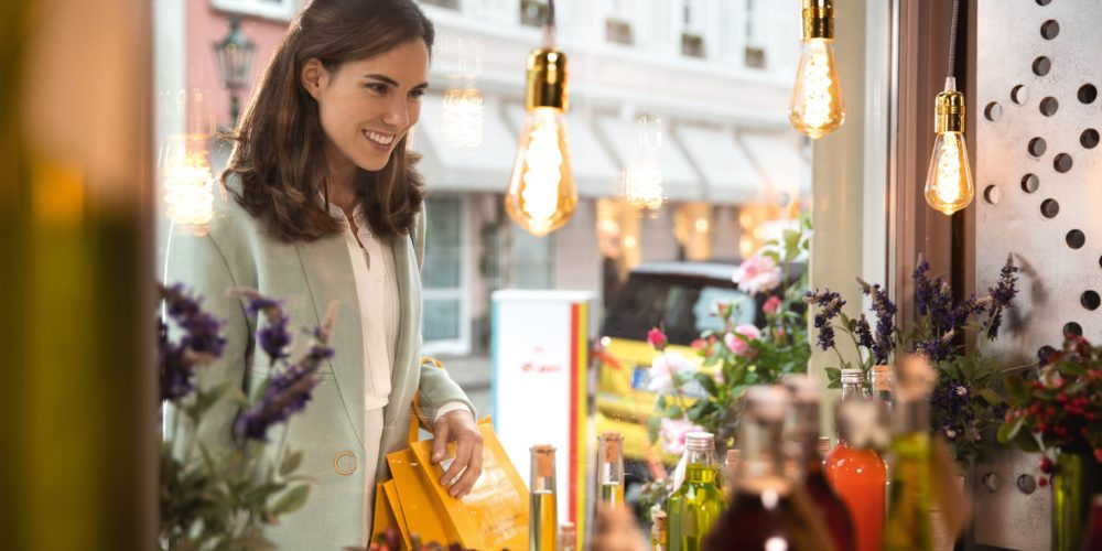 Una ragazza entra in un negozio per acquistare ingredienti per cosmetici fai da te, una scelta sostenibile per l’ambiente