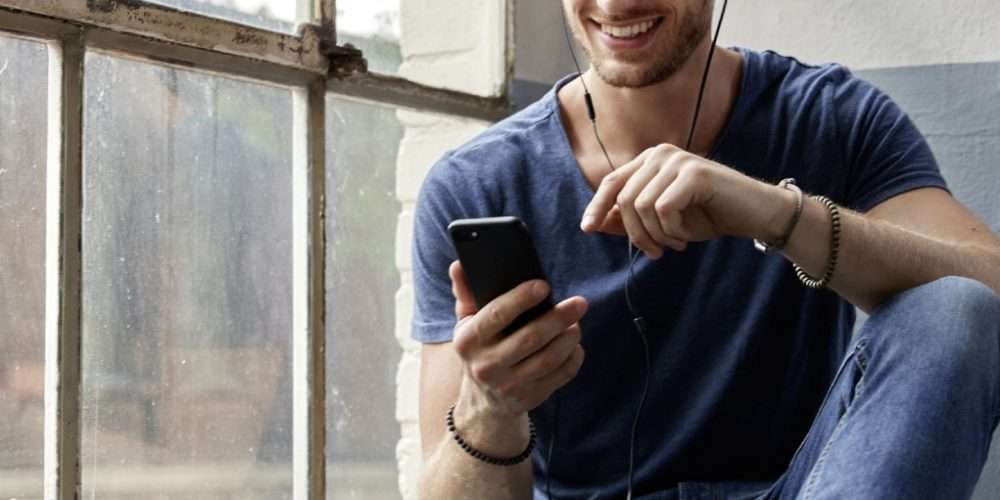 Un ragazzo sorride e controlla lo smartphone durante il Green Internet Day