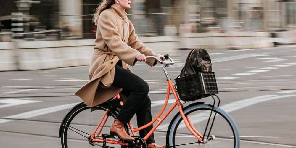 Una ragazza in bicicletta in città: piste ciclabili, monopattini e bici elettriche favoriscono la mobilità sostenibile