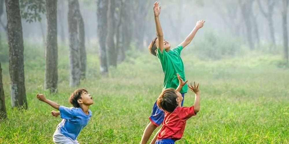 Dei bambini giocano all’aperto in un parco: l’educazione ambientale va insegnata fin dalla scuola primaria