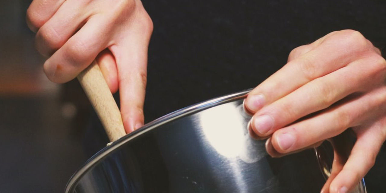 Mani al lavoro con paletta e pentola per una ricetta antispreco pasquale