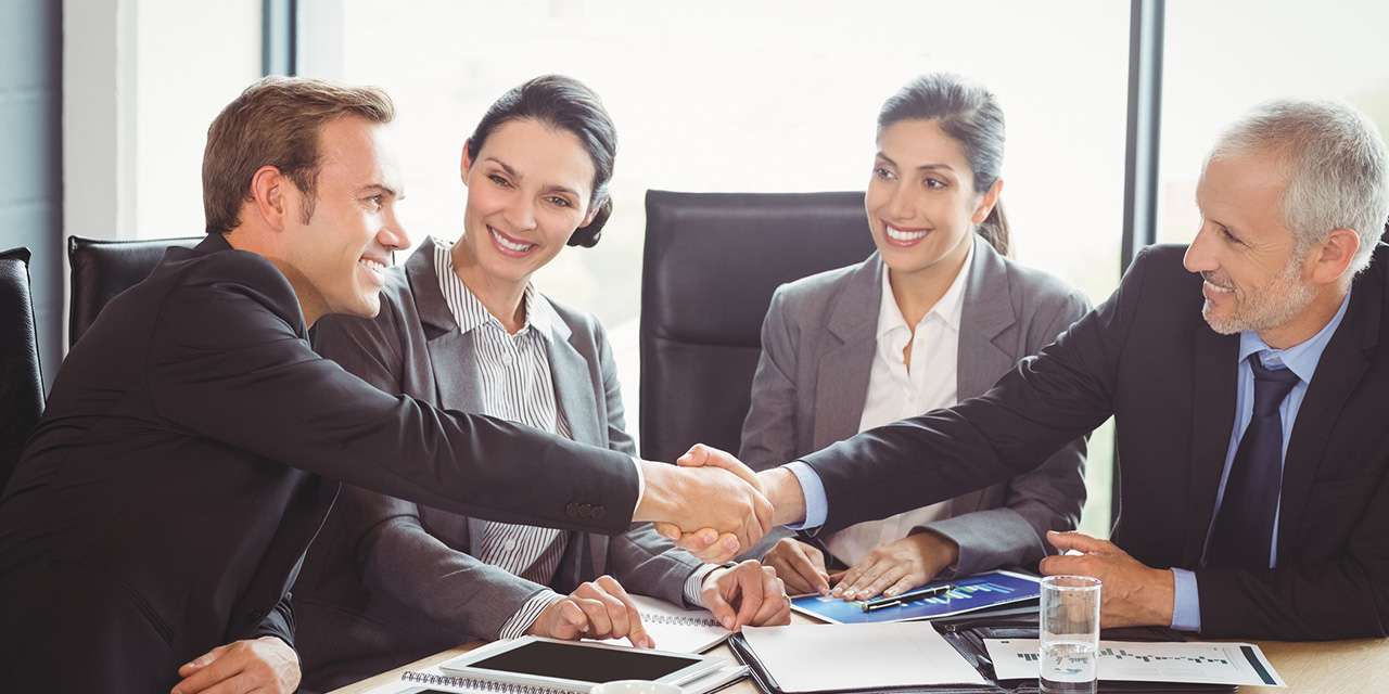 Una stretta di mano tra due uomini sancisce un affare: la gestione del credito è fondamentale per i condomìni