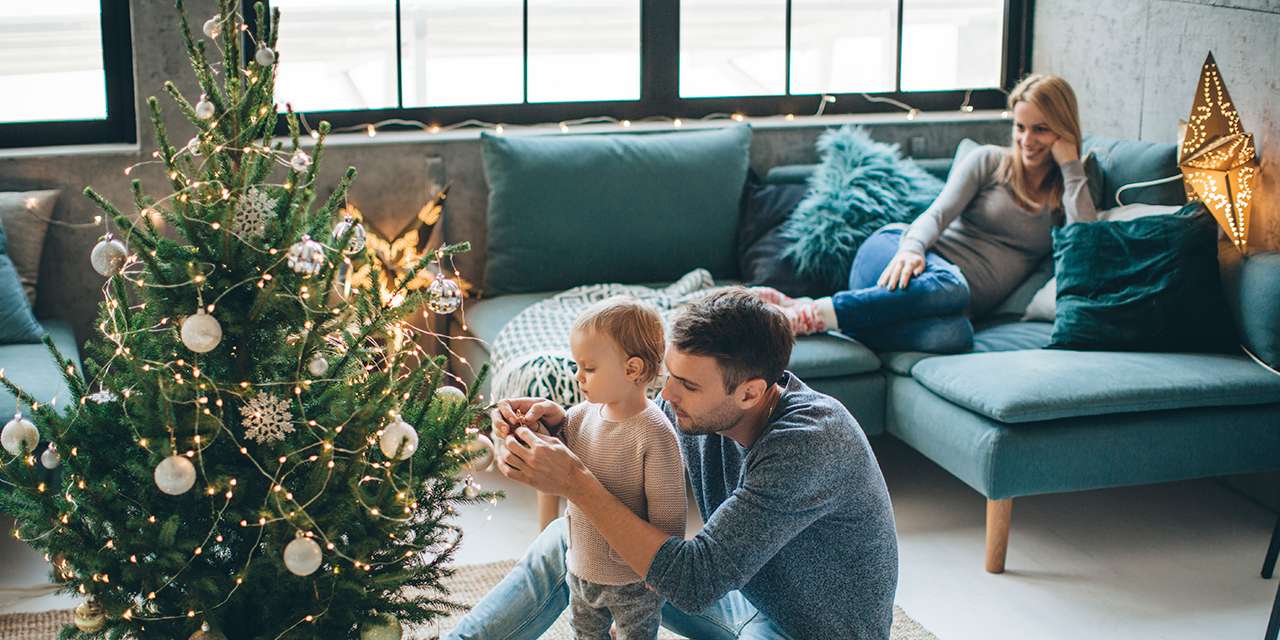 Un bambino decora l’albero di Natale con il papà: anche le decorazioni possono essere ecosostenibili