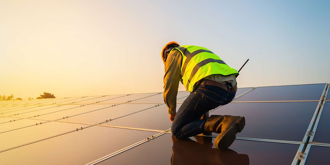 Un tecnico controlla dei pannelli fotovoltaici, il cui smaltimento deve seguire determinate procedure