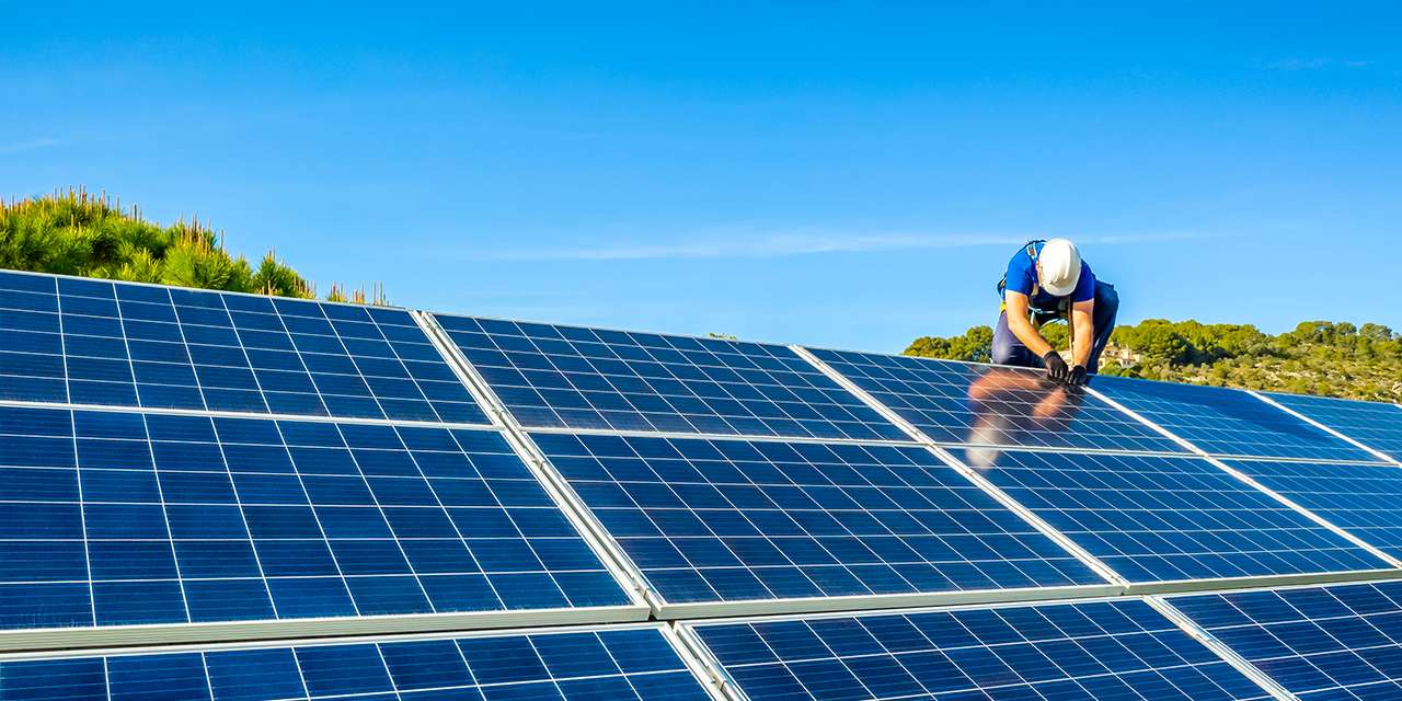 Un tecnico lavora su un tetto a un impianto fotovoltaico: i lavori green sono il futuro