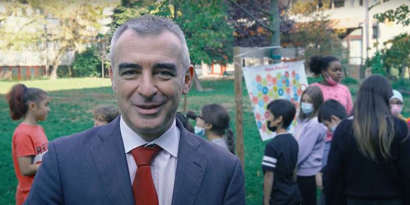 Andrea Giuliacci in un parco con dei bambini sullo sfondo per l’iniziativa Odiamo gli Sprechi di E.ON