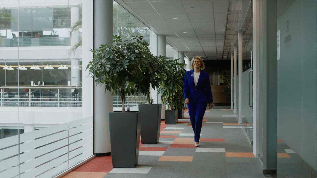 Una donna cammina in un corridoio di un’azienda: il risparmio energetico deve interessare anche gli uffici e i negozi