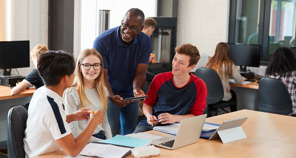 Dei ragazzi si confrontano con un professore in aula: l’istruzione può contrastare il fenomeno dei giovani inattivi, NEET