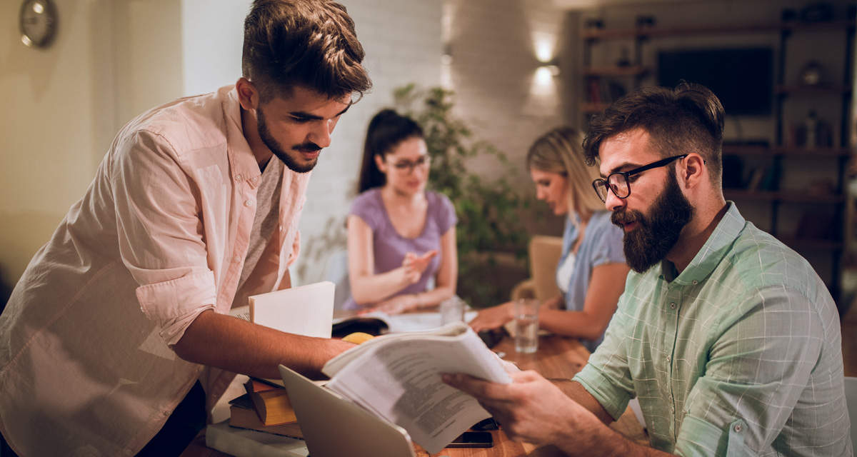 Condòmini intorno a un tavolo consultano documenti e valutano i primi passi per l’autoconsumo condominiale