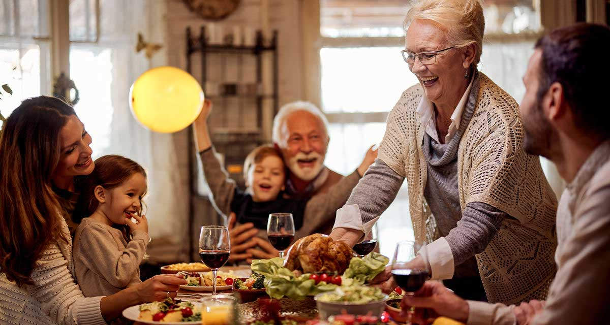 Una famiglia allargata ai nonni si ritrova intorno a una tavola imbandita per il pranzo
