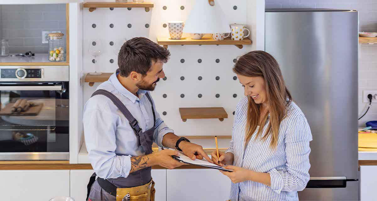Un tecnico fa firmare a una giovane donna un documento per la manutenzione della caldaia