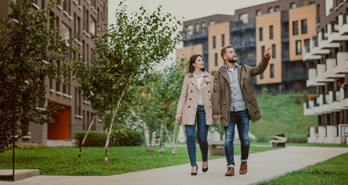 Una giovane coppia cammina in uno spazio verde condominiale