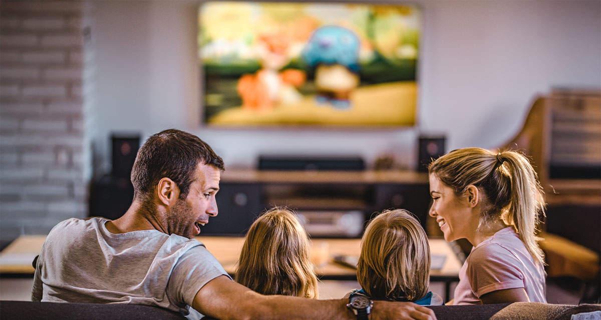 Una famiglia guarda la televisione in soggiorno: il canone rai è dovuto da chiunque possegga apparecchi con sintonizzatore TV