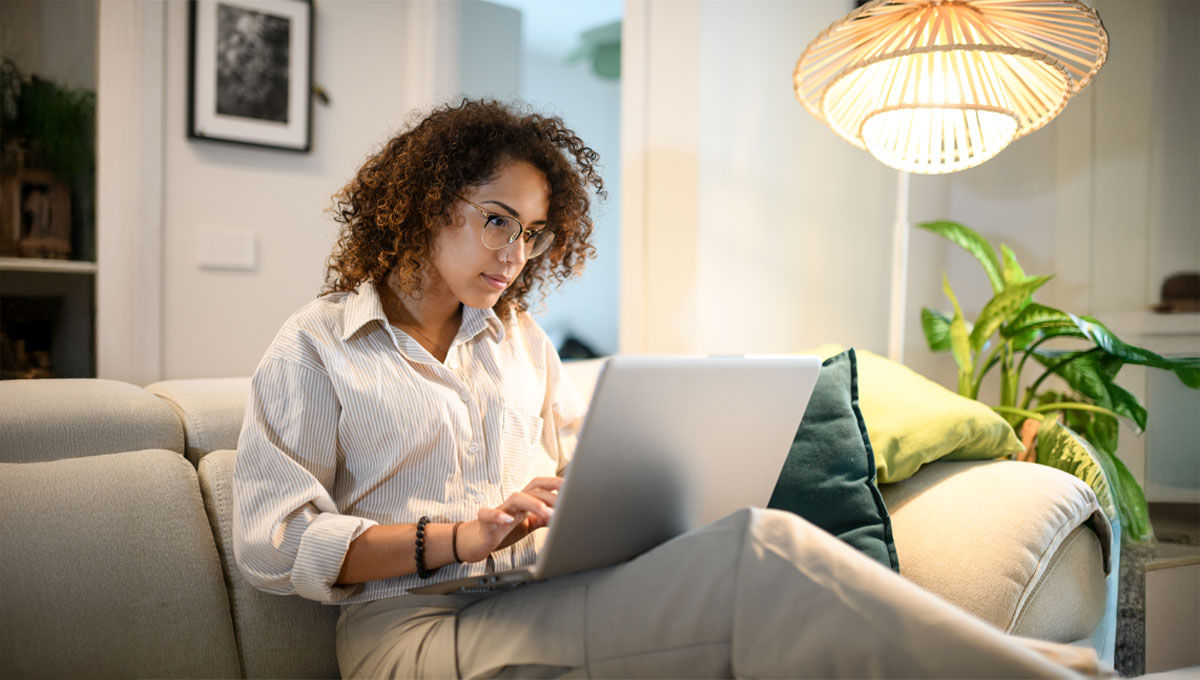 Una giovane donna nel proprio studio consulta soddisfatta il computer: con strumenti online si può valutare la convenienza di un’offerta luce