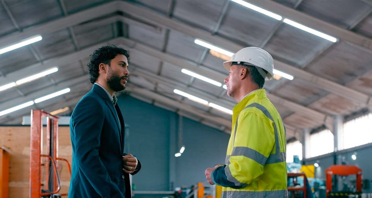 Un tecnico incontra un lavoratore in uno stabilimento durante le fasi preliminari della diagnosi energetica