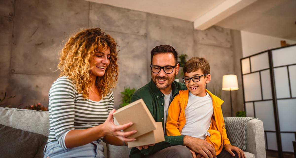 Una famiglia in un soggiorno illuminato artificialmente: la consapevolezza dei costi dell’energia elettrica fa risparmiare