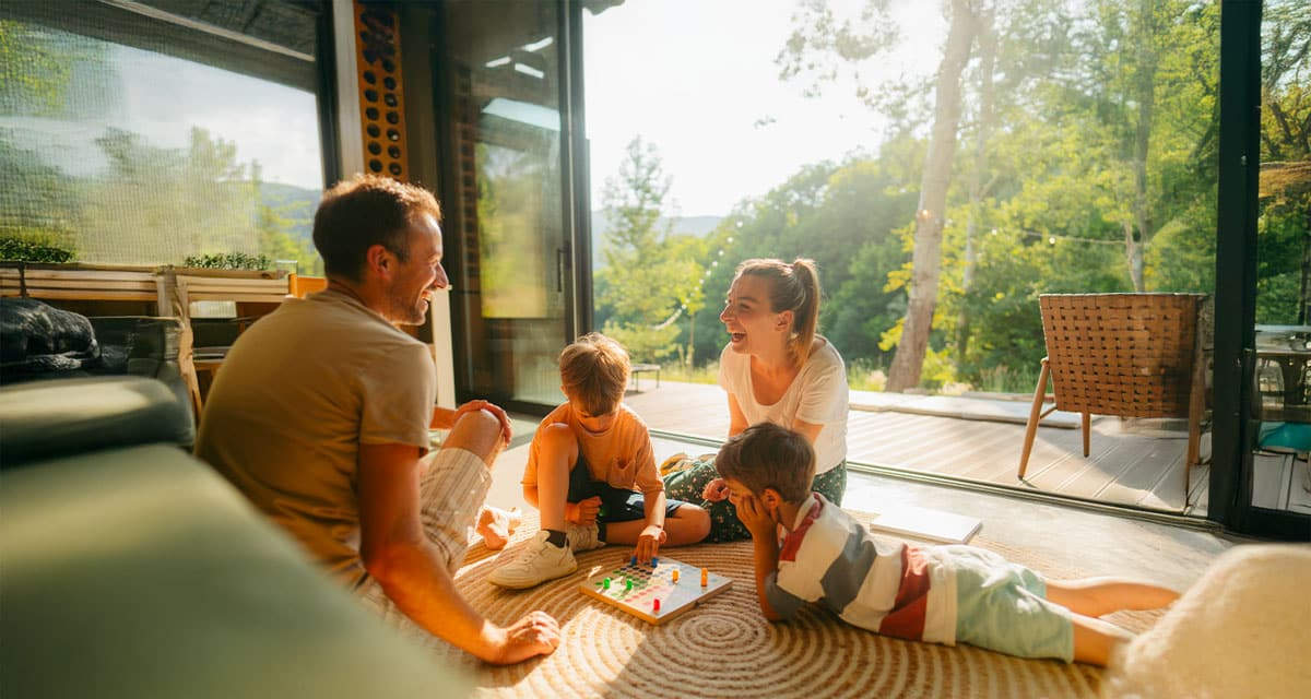 Una famiglia in un soggiorno assolato: modificare le abitudini favorisce la flessibilità energetica